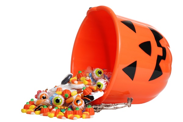 Halloween candy bucket upturned with candy spilling out