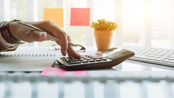 Man using a calculator to plan for dental costs in Rochester