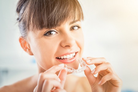 Greece NY woman placing Invisalign trays