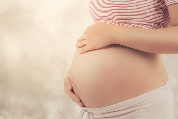 Woman with pregnant belly in the New York afternoon